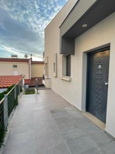 a walkway leading to a building with a black door at Phaedra Residence in Nikiti