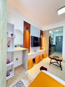 a living room with orange furniture and a tv at my cozy place in Nairobi +28 photos