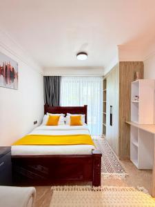 a bedroom with a large bed with yellow sheets at my cozy place in Nairobi