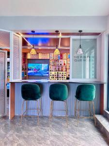 a bar with two green chairs in a restaurant at my cozy place in Nairobi