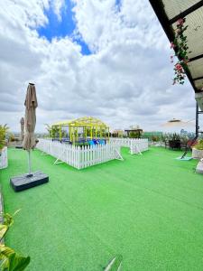 a playground on a green lawn with a white fence at my cozy place in Nairobi