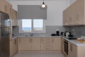 a kitchen with white cabinets and a window at Aegean colors Tinos in Tinos +71 photos
