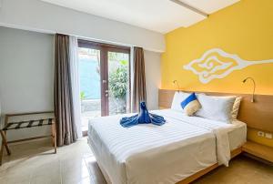 a bedroom with a large bed with a yellow wall at Kuta Beach Hotel in Kuta