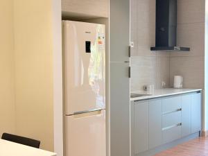 タシュケントにあるHanra Stayの白い冷蔵庫とシンクのあるキッチン