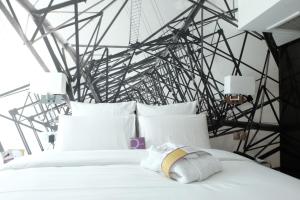 - une chambre avec un lit blanc et un mur en métal dans l'établissement Mercure Paris Malakoff Parc des Expositions, à Malakoff