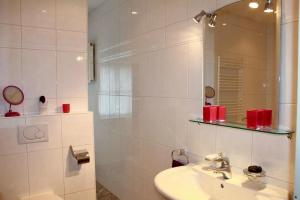 Un baño blanco con lavabo y espejo. en Stilvolles Landhaus mit Flair, en Menslage 46 fotos más