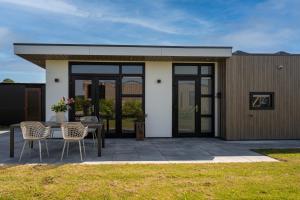 a house with a patio with a table and chairs at Sunray Anker in Molenschot