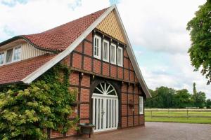 Una pequeña casa de ladrillo con una puerta blanca. en Stilvolles Landhaus mit Flair, en Menslage
