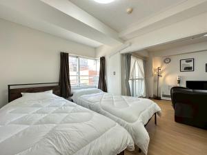 ein Schlafzimmer mit zwei Betten und einem Fenster in der Unterkunft NewOpenSapporo TanukikojiShimaya Building403 in Sapporo