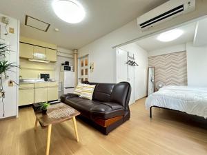 ein Schlafzimmer mit Couch und Bett und eine Küche in der Unterkunft NewOpenSapporo TanukikojiShimaya Building403 in Sapporo