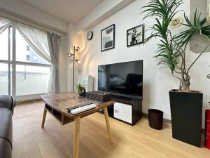 ein Wohnzimmer mit einem Couchtisch und einem TV in der Unterkunft NewOpenSapporo TanukikojiShimaya Building403 in Sapporo