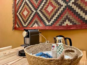 a basket on a table with a coffee maker and a rug at Terre Saracene Suites in Bitonto
