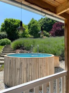 a circular pool in a wooden fence with two faucets at Landhaus Jule in Sankt Peter am Ottersbach