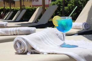 a blue drink in a glass sitting on a table at Agua Hotels Alvor Jardim in Alvor