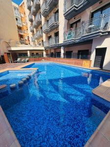 a large swimming pool in the middle of a building at Piso de SIMBA cerca de playa, con piscina y varias terrazas in Lloret de Mar