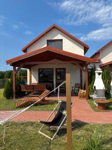 una casa con un'amaca di fronte di Domki Wypoczynkowe LUBKOWIA a Lubkowo Altre 40 foto