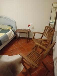 a room with a bed and two chairs and a table at Rive rosse in Masserano