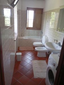 a bathroom with two toilets and a sink and a tub at Rive rosse in Masserano