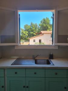 a kitchen with a sink and a window at Modern traditional tranquil house with garden in Nea Makri
