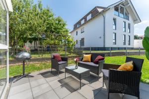 a patio with chairs and a table and a building at flair Apartment Blossom I BBQ I 2xParken I Terrasse I Kaffee I Waschmaschine I Disney plus in Fulda