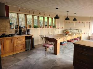 a kitchen with a large wooden table and chairs at La caronnière in Mervent