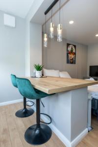 a kitchen with a table and a green chair at Namų mūza Self check in in Kaunas