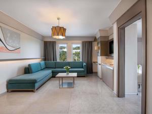a living room with a blue couch and a table at Rixos Premium Tekirova - The Land of Legends Access in Tekirova