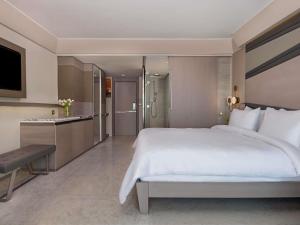 a bedroom with a large white bed and a kitchen at Rixos Premium Tekirova - The Land of Legends Access in Tekirova