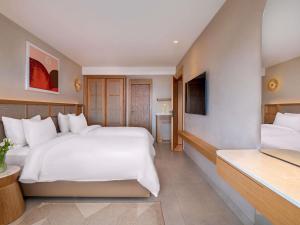 a hotel room with two beds and a television at Rixos Premium Tekirova - The Land of Legends Access in Tekirova
