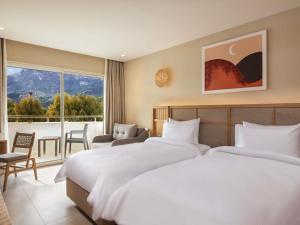 a hotel room with two beds and a balcony at Rixos Premium Tekirova - The Land of Legends Access in Tekirova