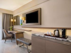 a room with a kitchen with a table and a tv at Rixos Premium Tekirova - The Land of Legends Access in Tekirova