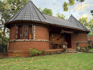 a small brick house with a black roof at The Fort Valley BnB , Karatu in Karatu +10 photos