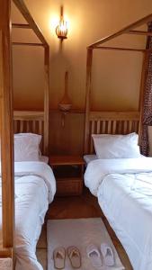 カラトゥにあるThe Fort Valley BnB , Karatuのベッド2台とスリッパ2足を備えた寝室 +8枚の写真