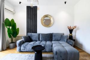 a living room with a blue couch and a mirror at Belgrade CITY CENTER Apartments PARKING 12e - 7 min by walk TERAZIJE in Belgrade