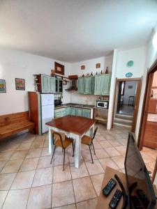 维拉西米乌斯Casa Pepe Confortevole villetta con giardino a 2 min dal mare的房间里有一张桌子和几把椅子的厨房