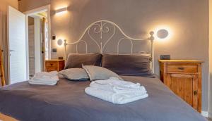 科利科Alle Macine - Lake Como Heritage Home in Molino Maufet Watermill - Lake View Balcony的一张带两条毛巾和两个枕头的床