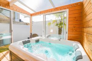 una grande vasca da bagno in una stanza con finestra di Casa Gauda, Jacuzzi, détente et sérénité a Falaise Altre 31 foto