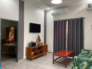 a living room with a bed and a tv and a couch at Jampun Pool Villa in Klong Muang Beach