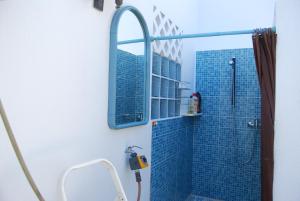 クアルテイラにあるQuinta do Romãoのバスルーム(青いタイル張りのシャワー、鏡付)