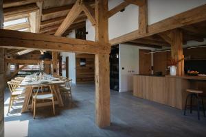 a dining room with a table and chairs and wooden ceilings at Chalet Plume - OVO Network in Morzine