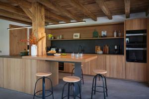 a kitchen with a wooden counter and stools in it at Chalet Plume - OVO Network in Morzine +22 photos