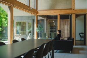 a woman sitting at a table in a room at Villa Metsä KARUIZAWA in Karuizawa