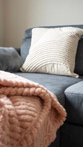 a blanket sitting on a blue couch with a pillow at Pinkerton House in Dunfermline