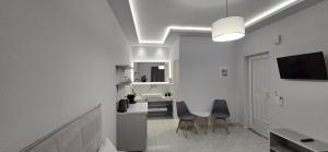 a white bathroom with a sink and a table and chairs at Villa Georgia in Argassi