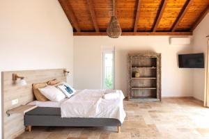 a bedroom with a bed and a wooden ceiling at Spacious new villa with pool above the pristine beach - FIRST SEASON PRICING!!! in Prvić Šepurine