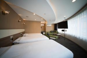 a hotel room with two beds and a television at Super Hotel Ikebukuro-Eki Kitaguchi in Tokyo