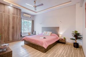 a bedroom with a large bed with a pink blanket at BOHO Bari in Kolkata