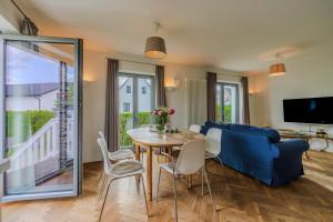 a living room with a table and a blue couch at Ferienhaus Wohrbarg Ferienhaus Wohrbarg in Timmendorfer Strand