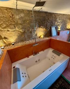a bath tub in a room with a stone wall at Il Rivellino - Tamerò Estates in Casperia