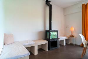 Una sala de estar con televisión y un sofá. en Ti Ar Mor Braz- Maison avec grand jardin, en Saint-Philibert